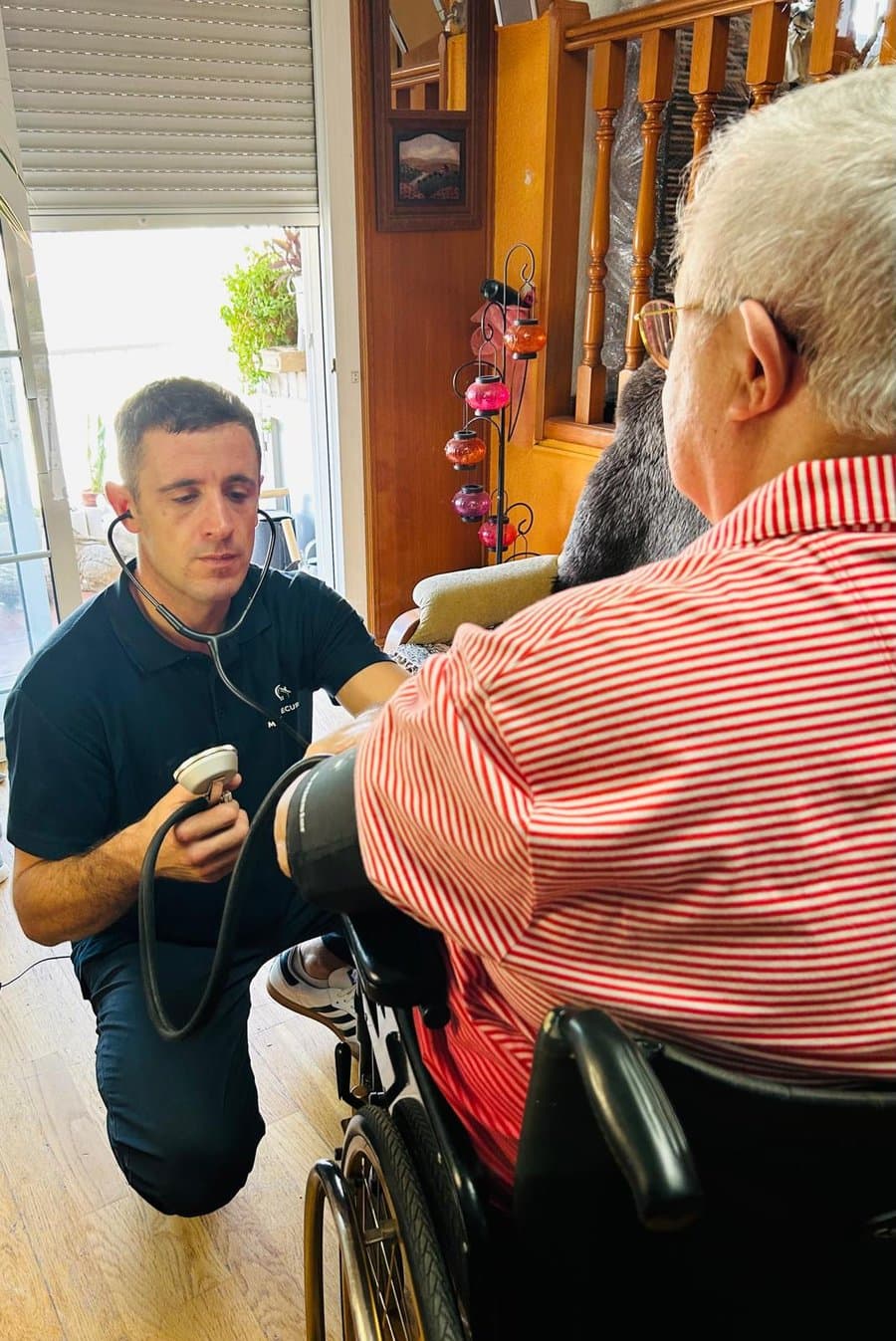 Jorge tomando la tensión a un paciente en su domicilio como parte del seguimiento de constantes vitales